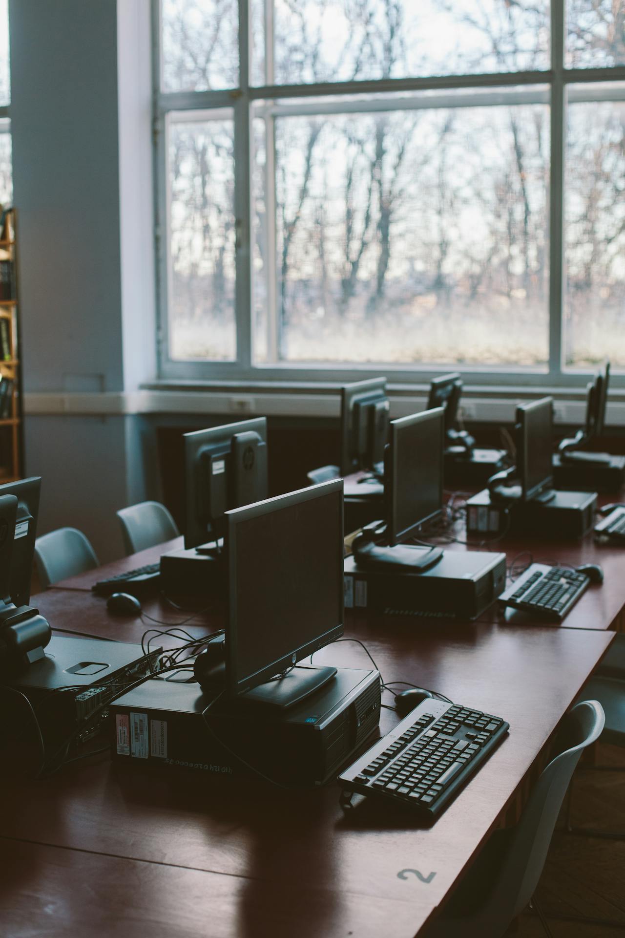 View of a classroom full of computers at multiple desks.